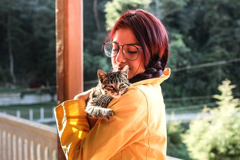 femme qui porte un chaton contre elle